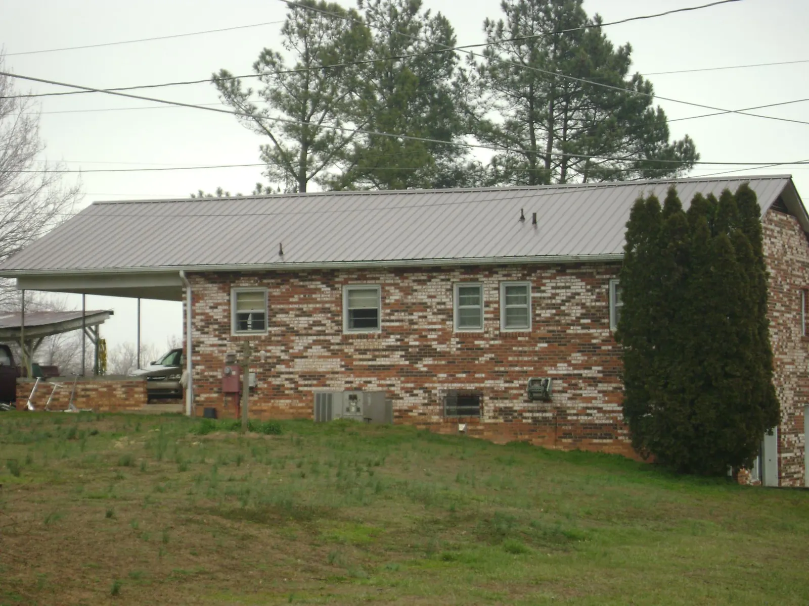 Gray metal roof on a brick split level home with a carport in Pageland