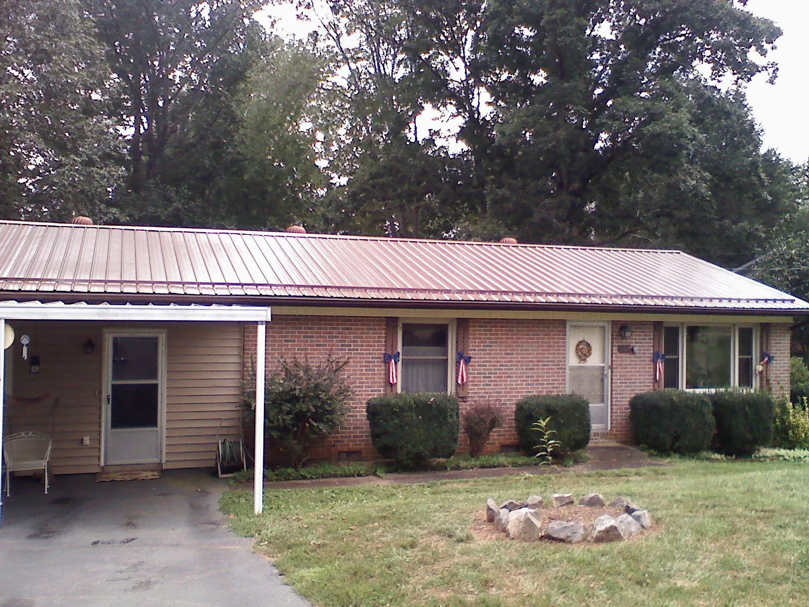 Bronze metal roof and carport on a brick ranch home — Roof Repair work by our crew in Pageland