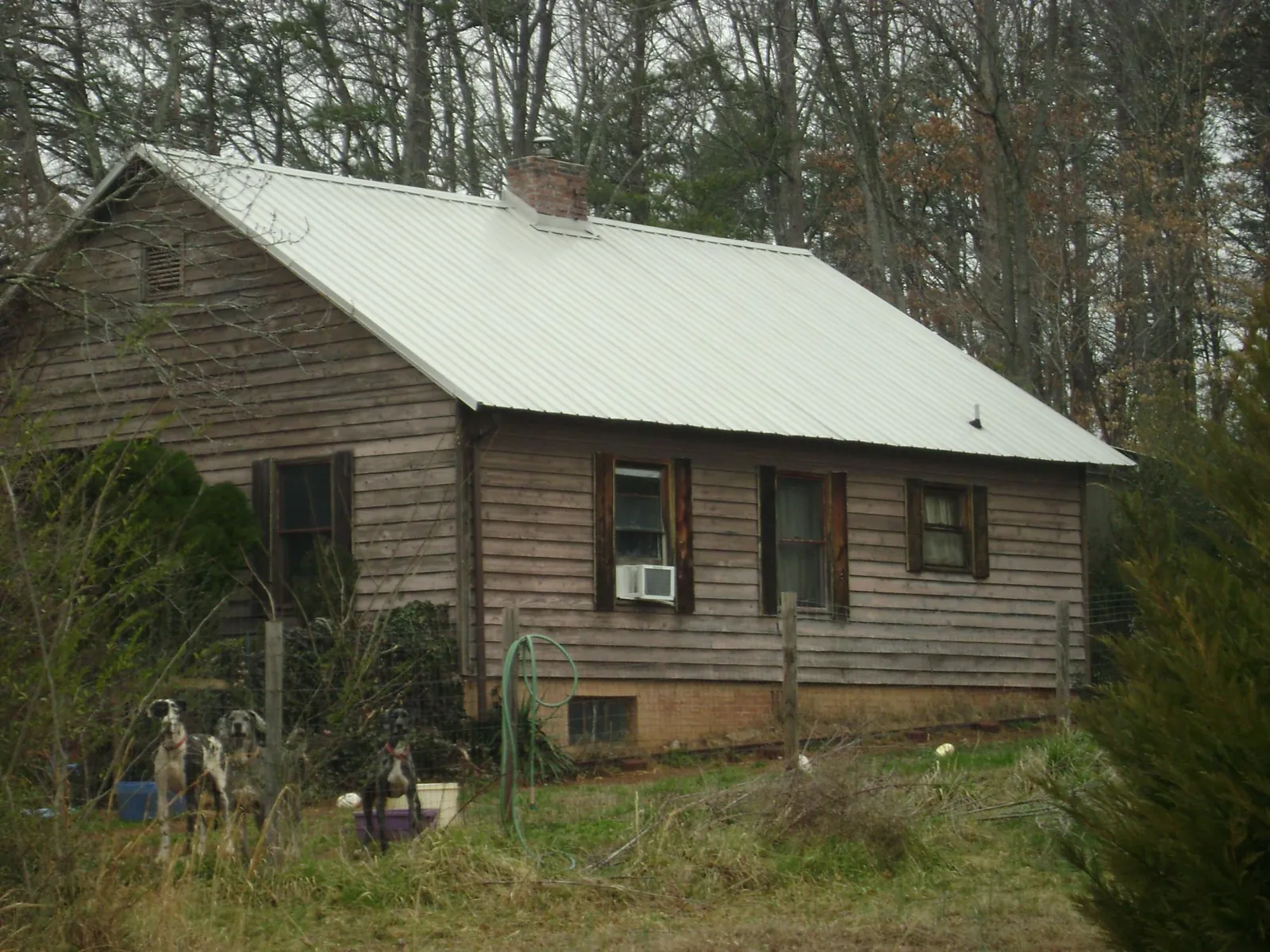 White metal roof on an old wood sided farmhouse, from a Metal Roof Installation job in Pageland